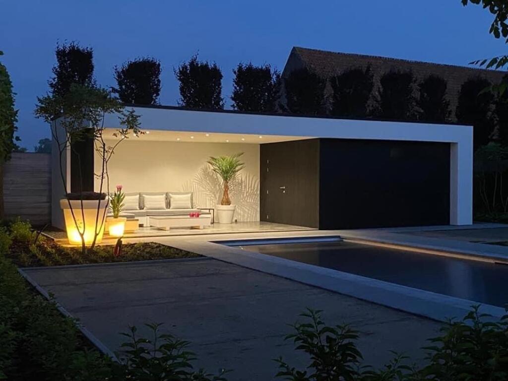 Black & White poolhouse met zwarte Meranti gevelbekleding door Magard by night