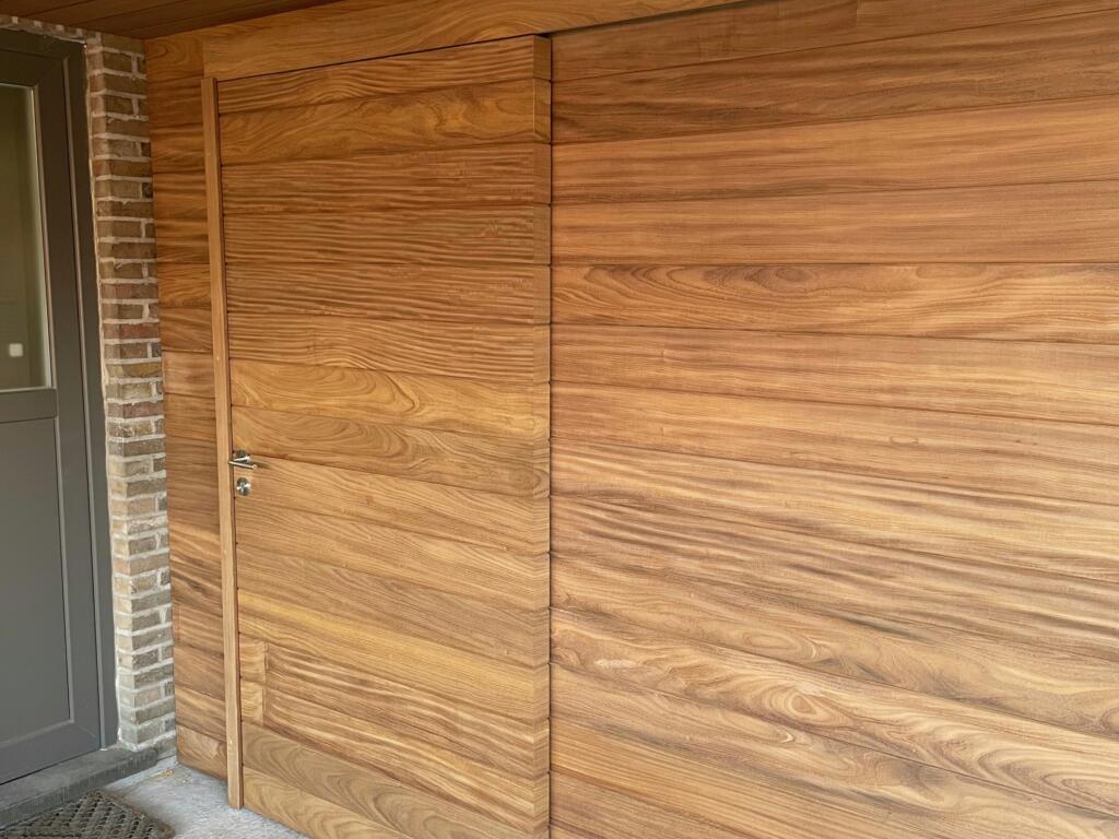 Moderne houten carport in afrormosia en ayouis met ingewerkte deur