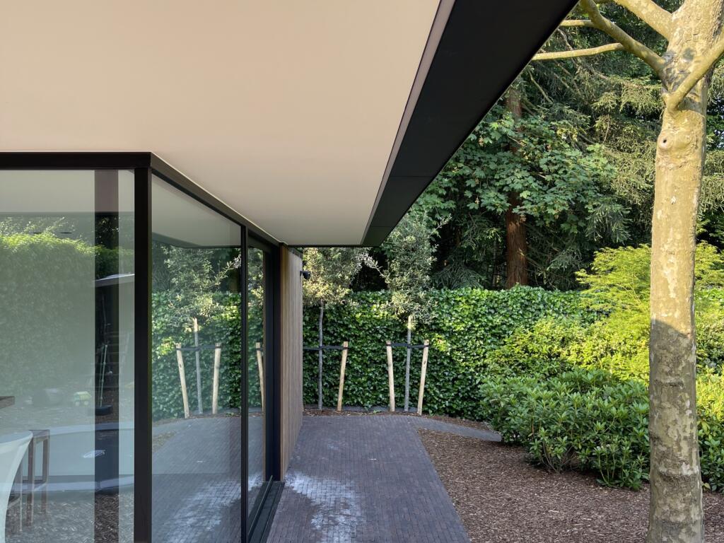 Zijkant modern poolhouse onder uitstekende dakrand