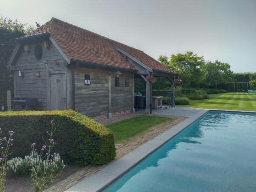 Zijaanzicht Zuiders houten poolhouse in eik