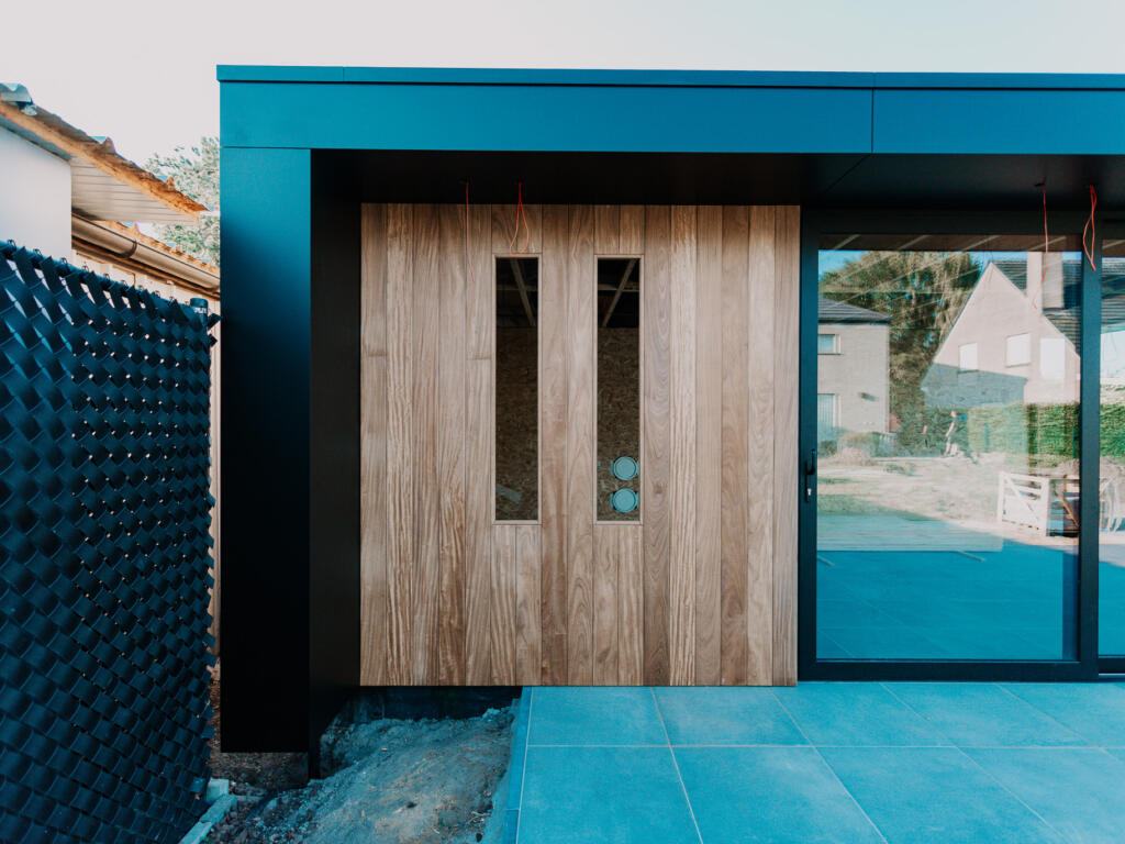 Vooraanzicht modern poolhouse in afrormosia gevelbekleding