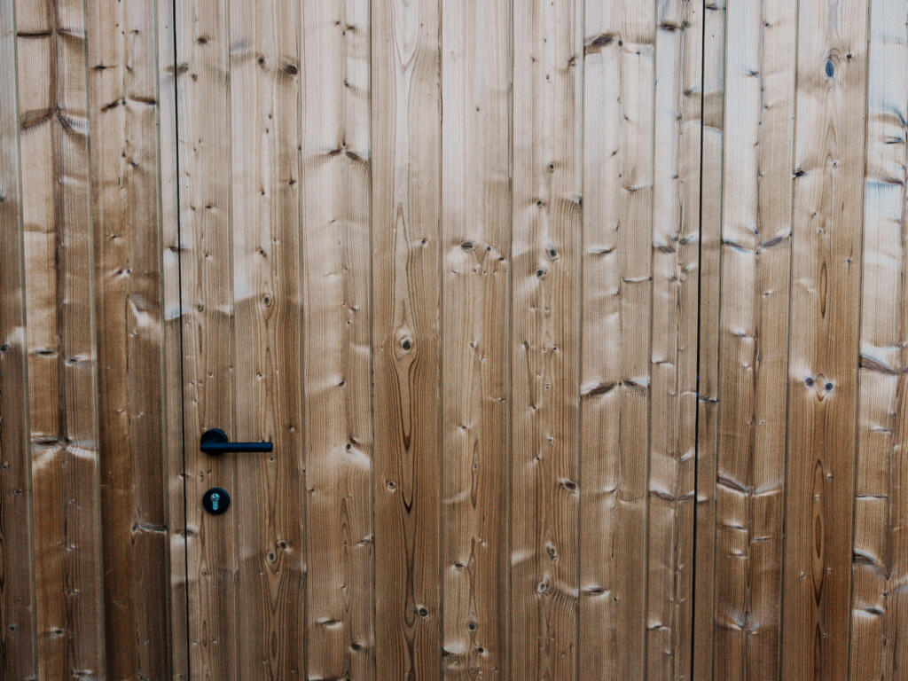 Detailbeeld van de ingewerkte deur in de afrormosia gevelbekleding