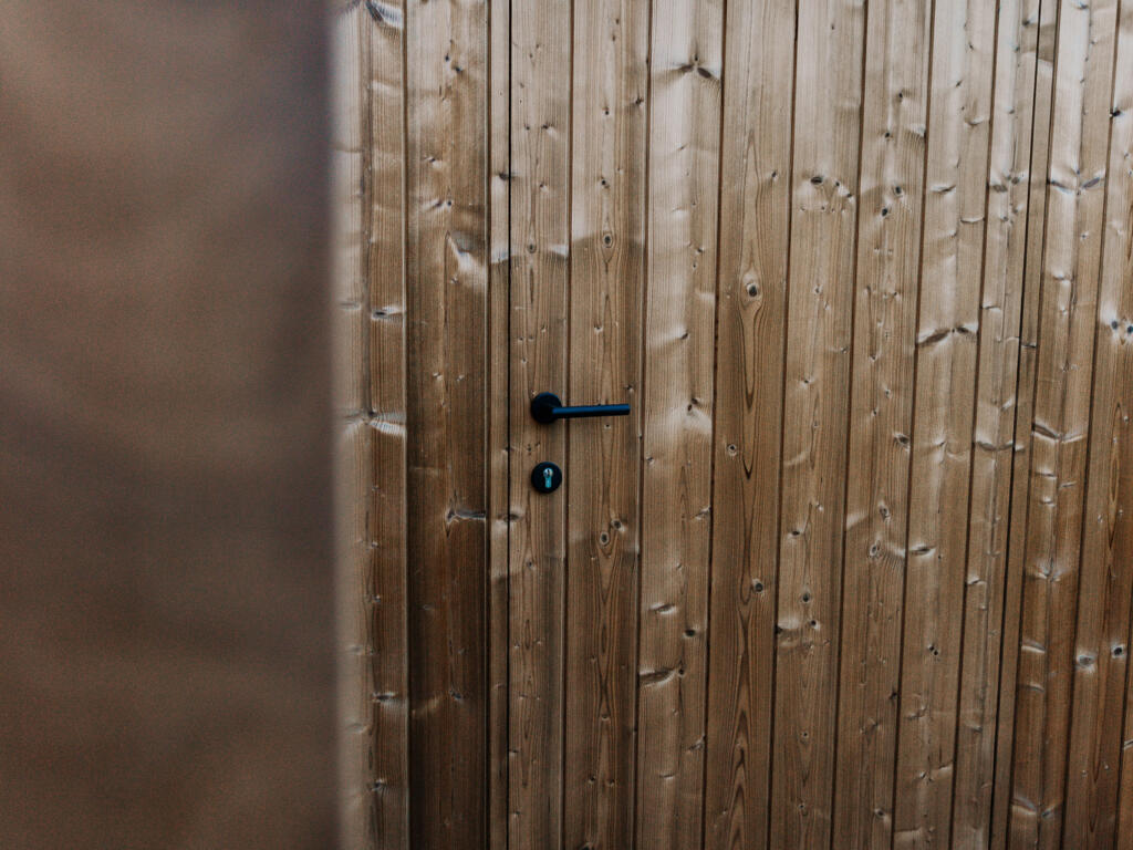 Detailbeeld van de ingewerkte deur in de afrormosia gevelbekleding